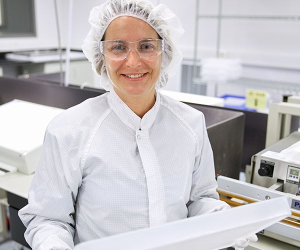 Técnico sosteniendo una bandeja LYOGUARD en la sala blanca