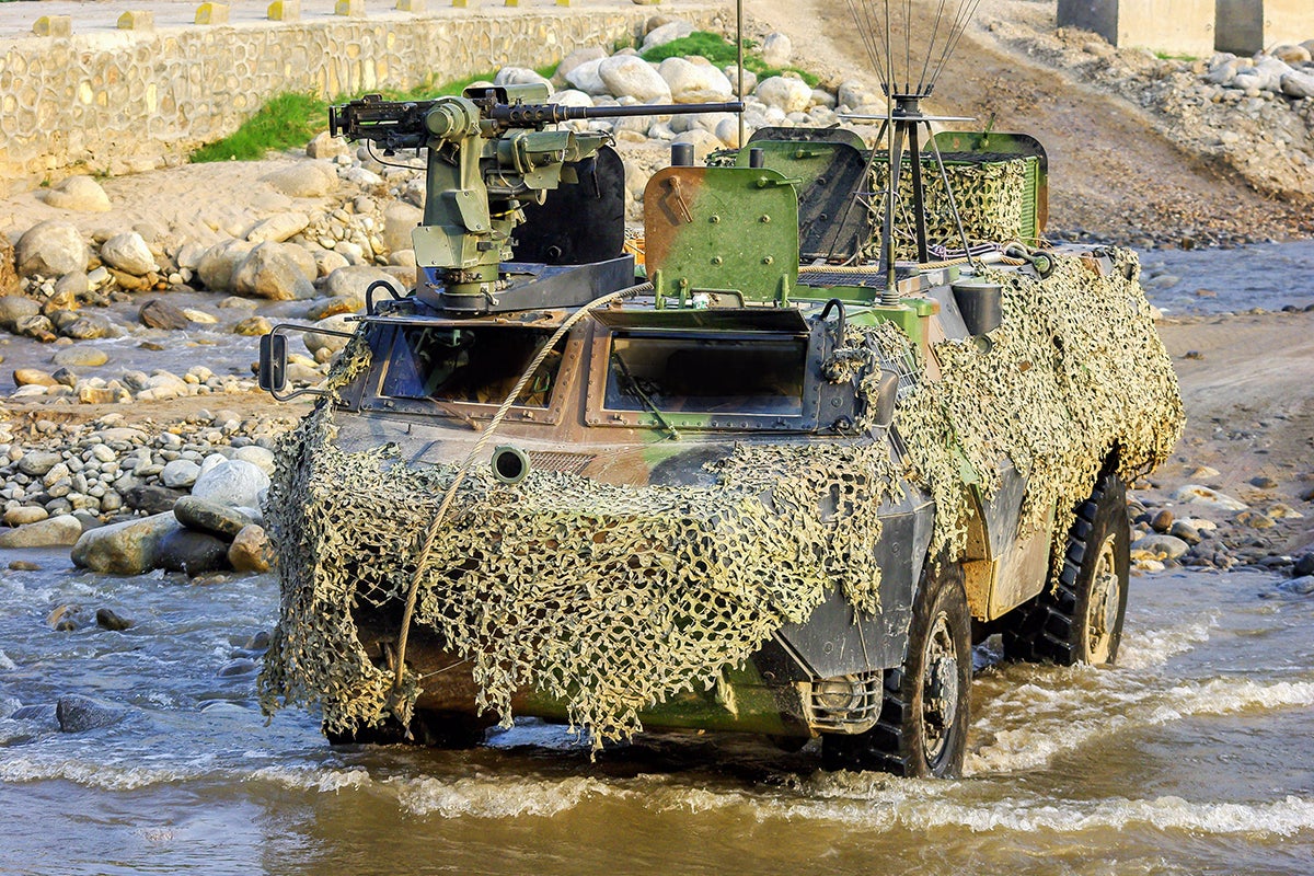 Tanque blindado con camuflaje en un río