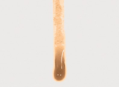 Primer plano de un líquido marrón adhiriéndose a la superficie de una membrana de la competencia. El líquido no se repele y obstruye la membrana, reduciendo el caudal de aire.
