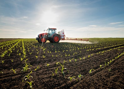 Imagen diurna de un tractor aplicando bioestimulantes en el campo.
